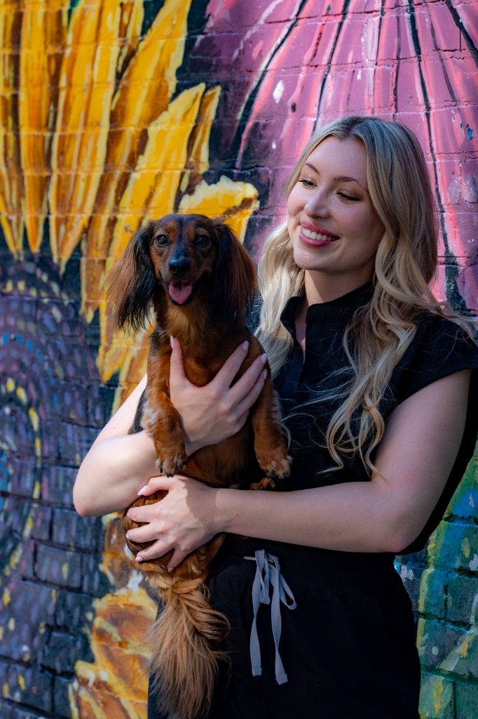 Marvin's Mum in scrubs holding Marvin in front of a mural